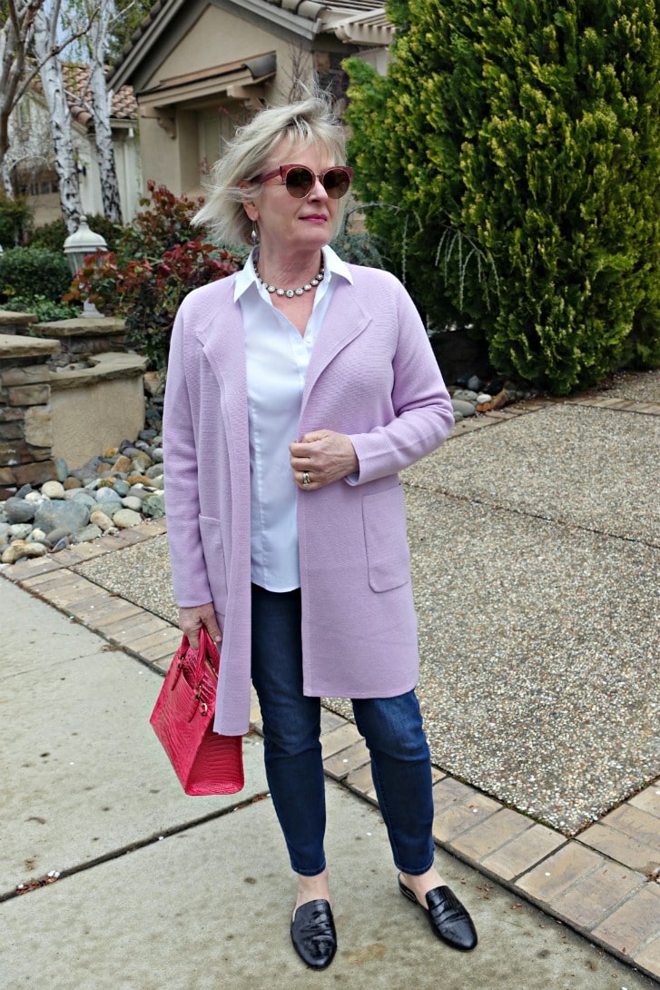 casual outfit with sweater blazer over blue jeans, white shirt and pink handbag