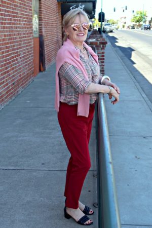 Jennifer Connolly wearing casual outfit with flannel shirt and red pants from J Jill at railing on sidewalk