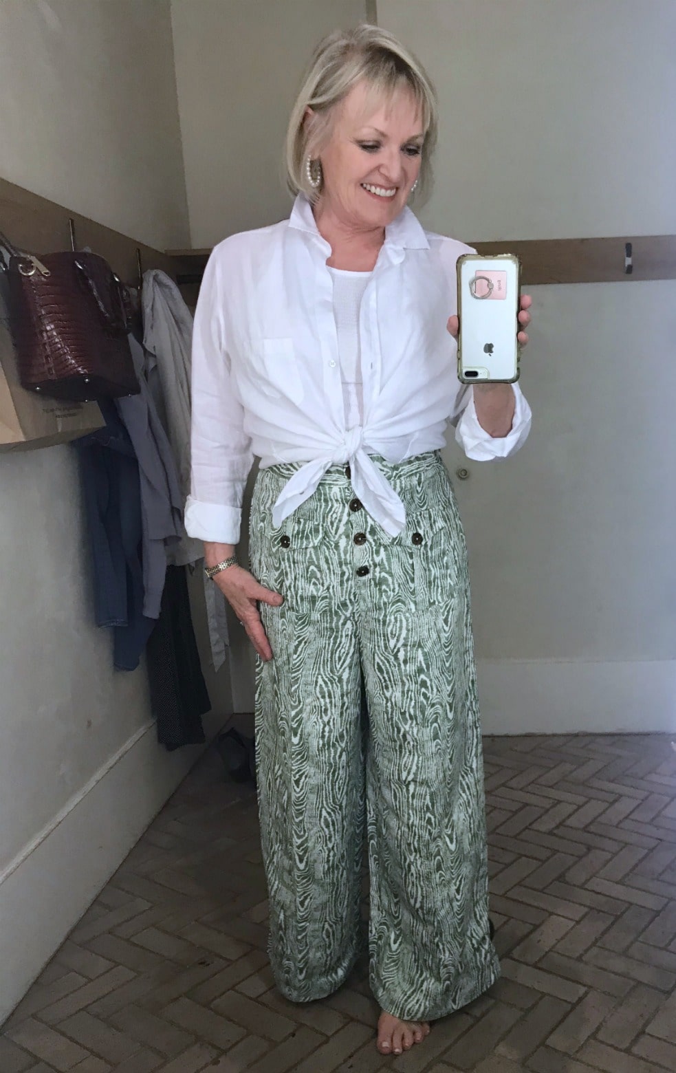 Jennifer Connolly of A Well Styled Life wearing white linen shirt and wide leg green print pants from Anthropologie