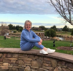 over 50 fashion blogger jennifer connolly of a well styled life wearing blue hoodie and blue sweater pants with white sneakers