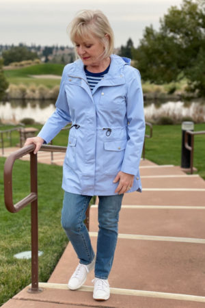 woman walking up the stairs in blue anorak and blue jeans