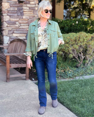 over 50 blogger jennifer connolly of a well stylesd life wearing loghtweight fall outfit of green utility jacket, soft blouse and jeans