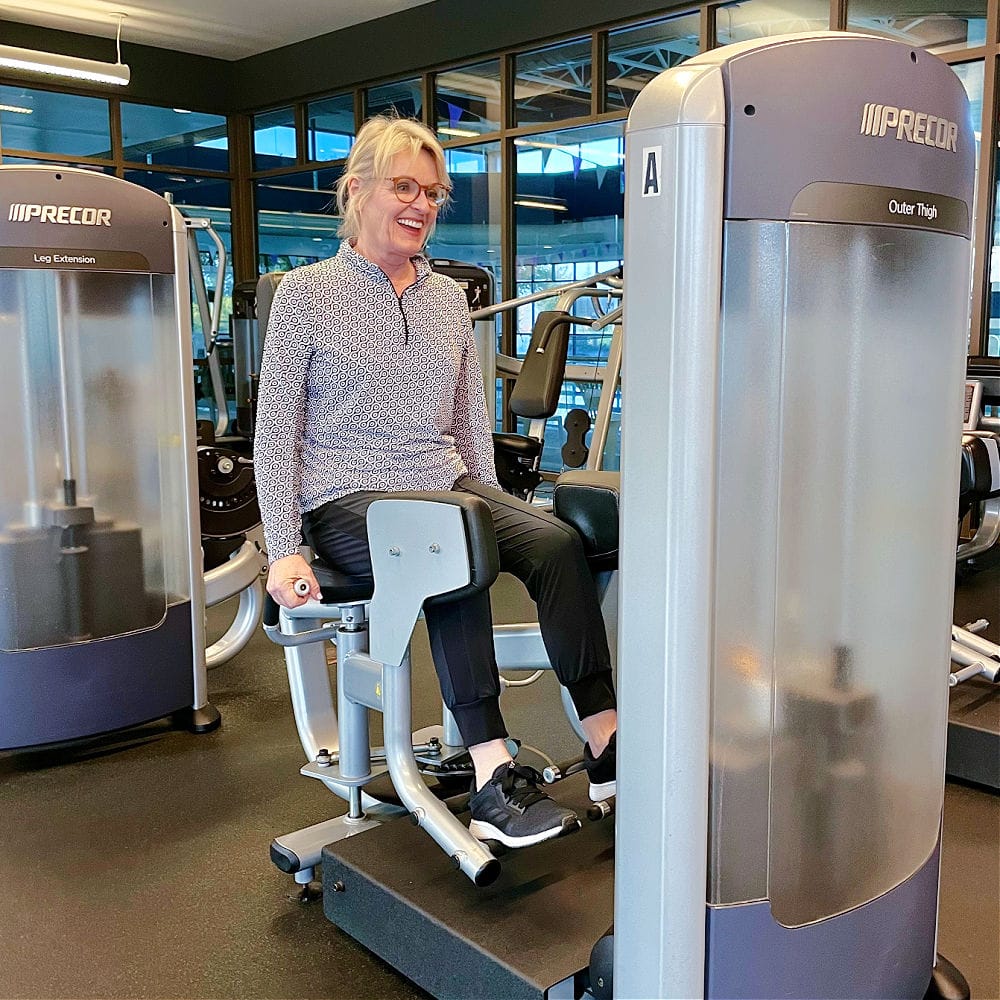 senior woman using machine in gym