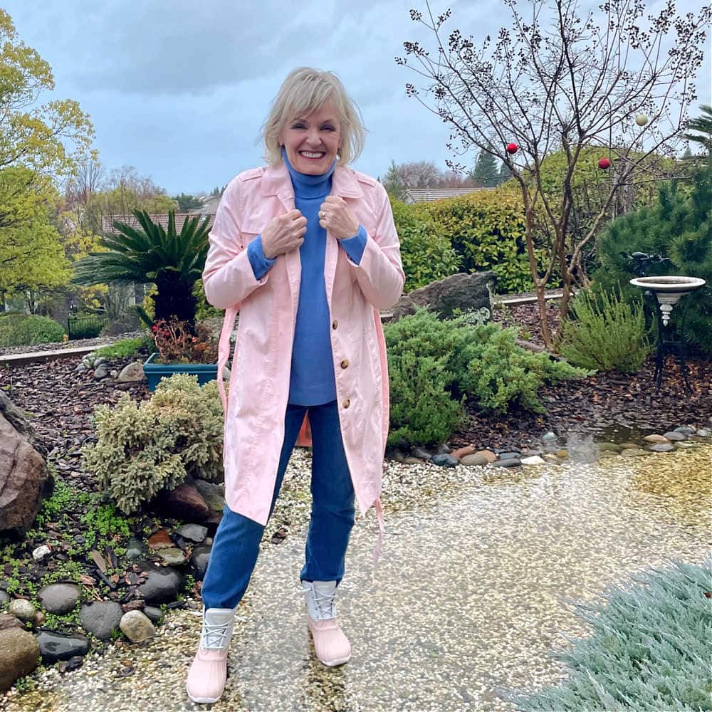over 50 blonde woman wearing pibk rain coat and rain booties