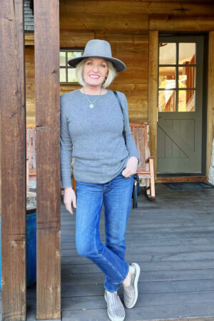 woman wearing cashmnere sweater, wool fedora and paige jeans