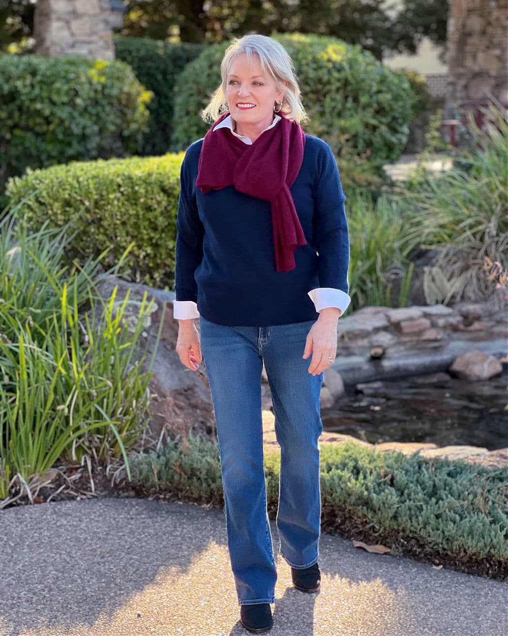 jennifer connolly of a well style life wearing navy cashmere sweater and cashmere scarf with bootcut jeans