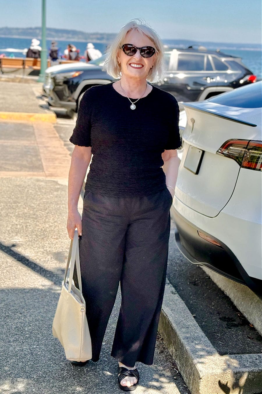 All-black outfit for women over 60 with bubble crew neck top, wide-leg cotton pants, and sandals