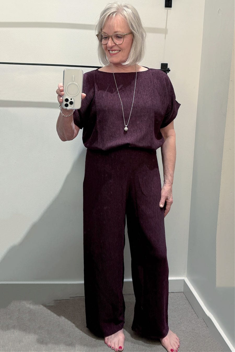 Woven plissé dolman sleeve top tucked into matching pleated wide-leg pants in a soft neutral tone