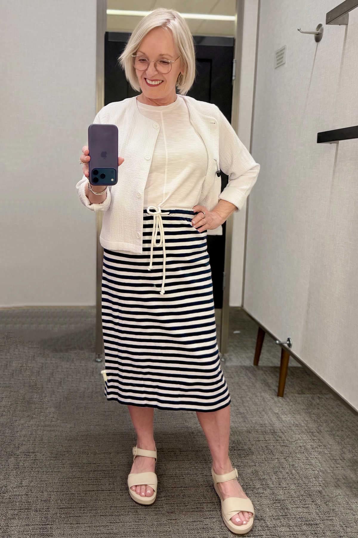 Modern nautical summer look featuring a lightweight white cotton gauze jacket and a navy striped knit midi skirt.