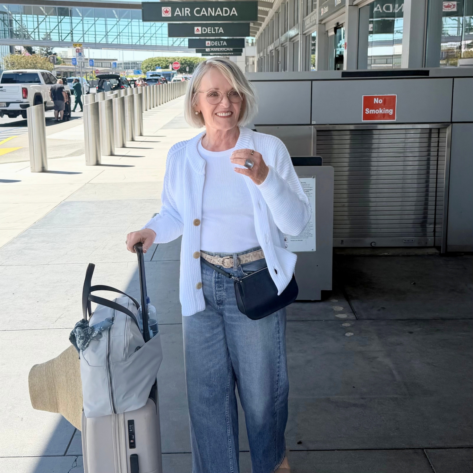 WHITE COTTON SWEAR AND MIRAMAR FLEECE JEANS ON WOMAN ARRIVING AT AIRPORT