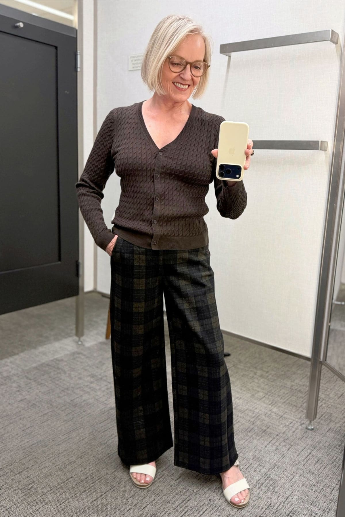 Nordstrom Brown cable-knit V-neck cardigan paired with navy-and-ginger plaid wide-leg trousers.